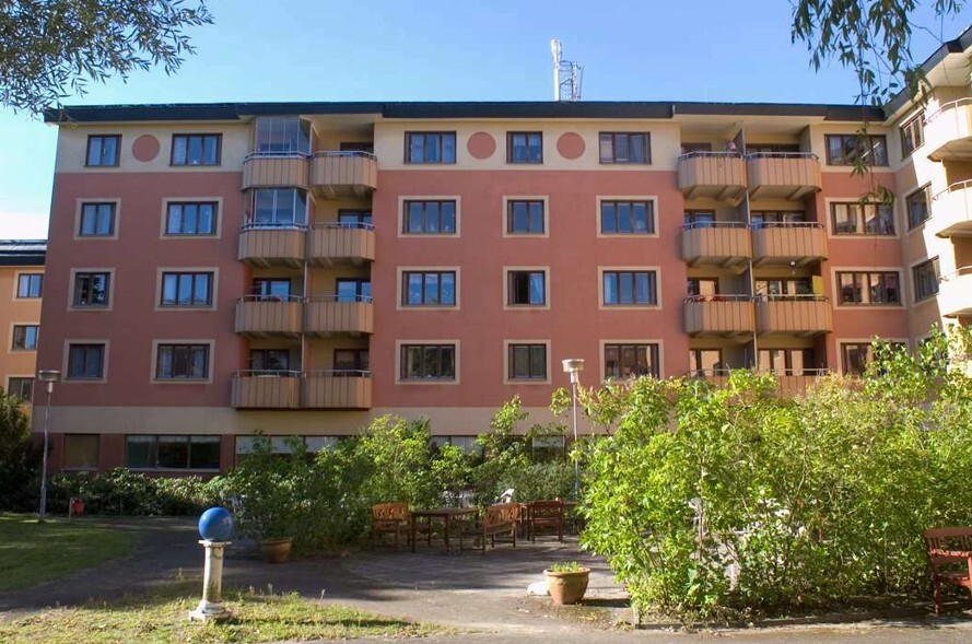 Enskededalens servicehus med ljusröd fasad och gula balkonger. Ebab har ansvarat för byggledningen i den omfattande ombyggnaden. n.