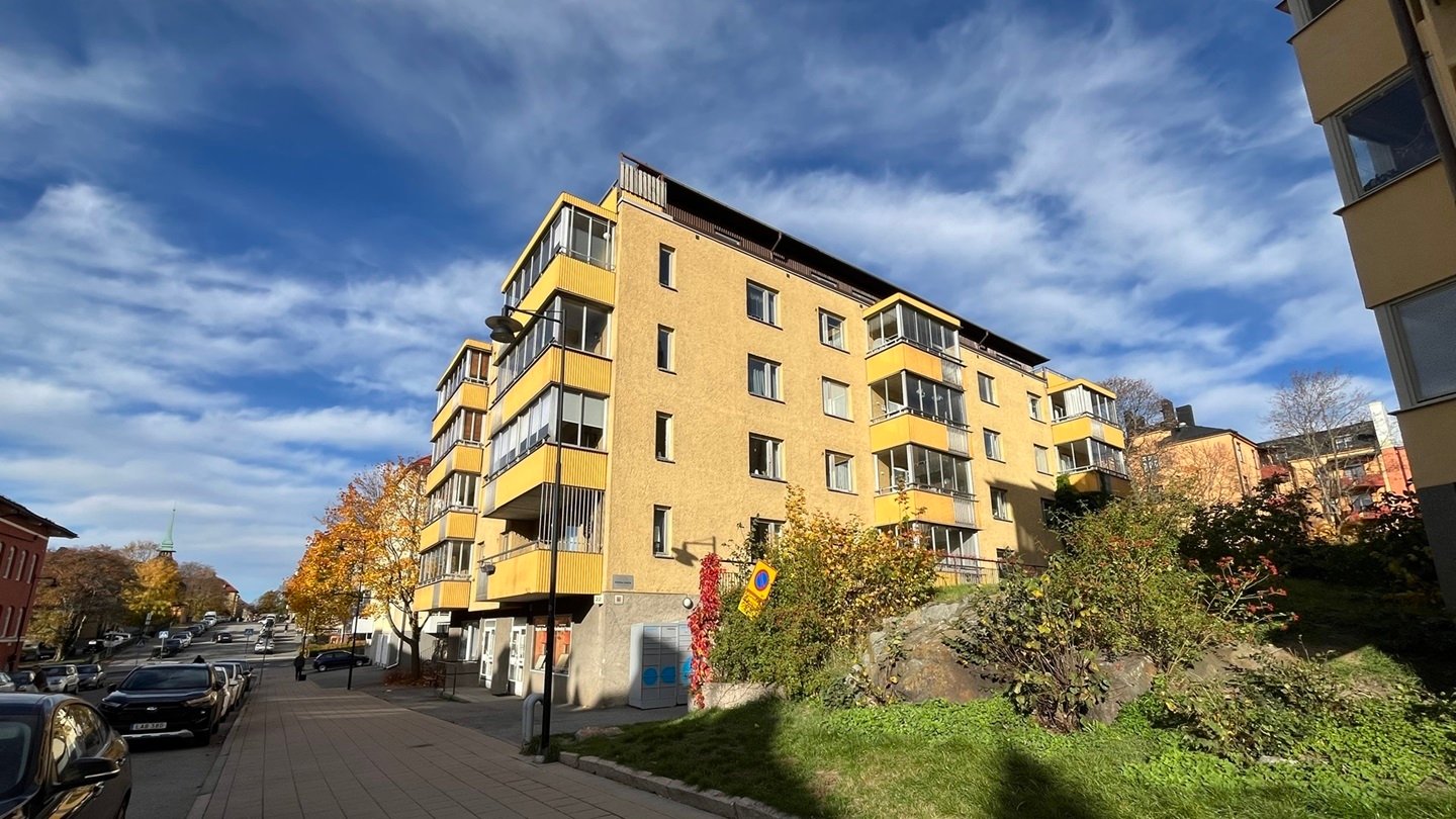 Fasader i gul puts med gula balkonger mot en blå himmel. 