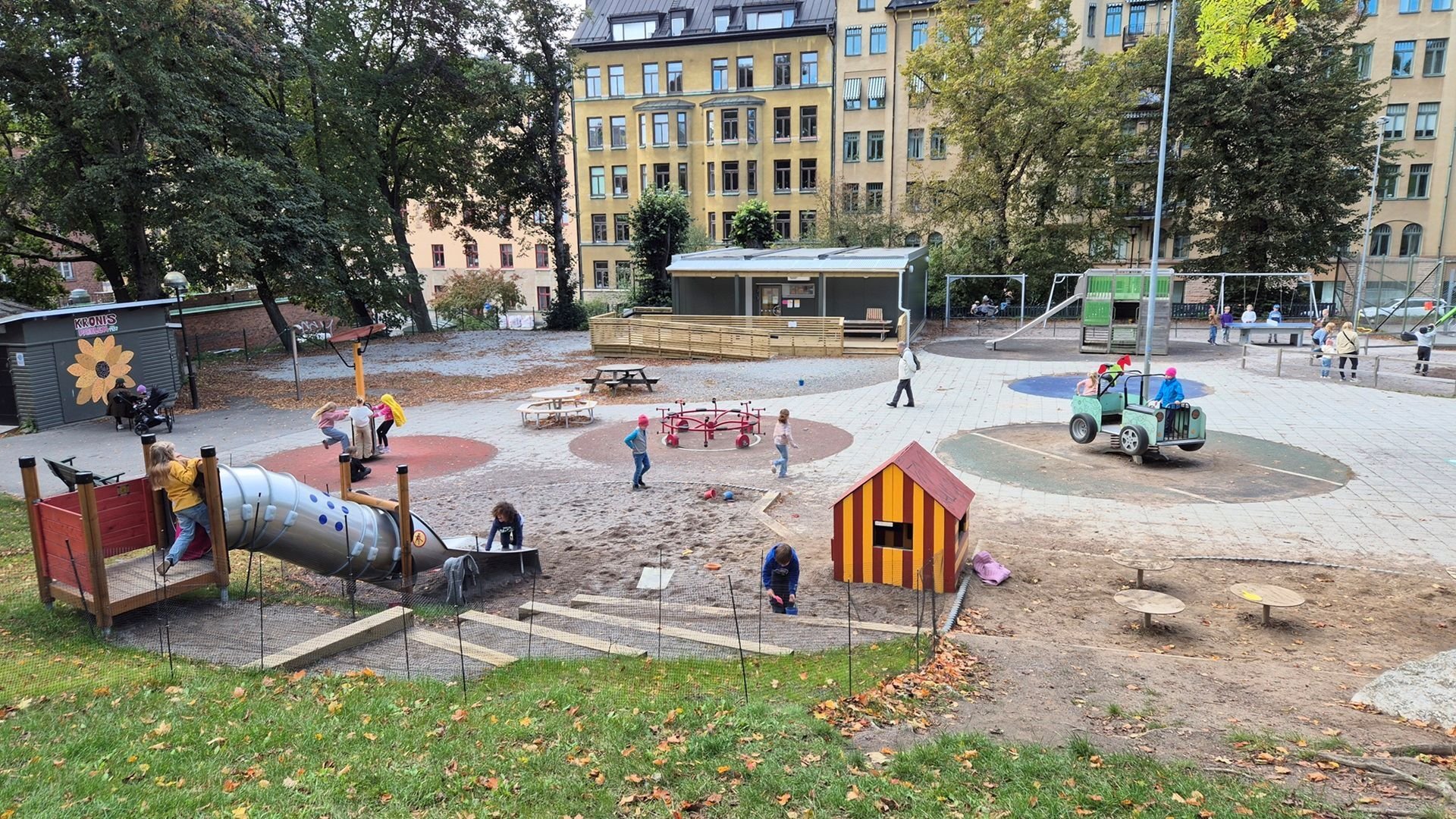 Kronobergsparkens parklek där barn leker i olika lekredskap. Ebab medverkade vid återställning efter brand.
