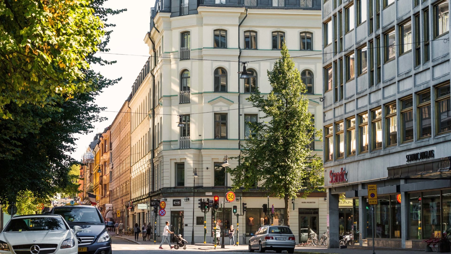 Fasad i ljus puts i Sperlingens backe med ett träd i förgrunden. Ett innerstadprojekt i bästa läge där Ebab medverkat med projekt, projekterings- och byggledning