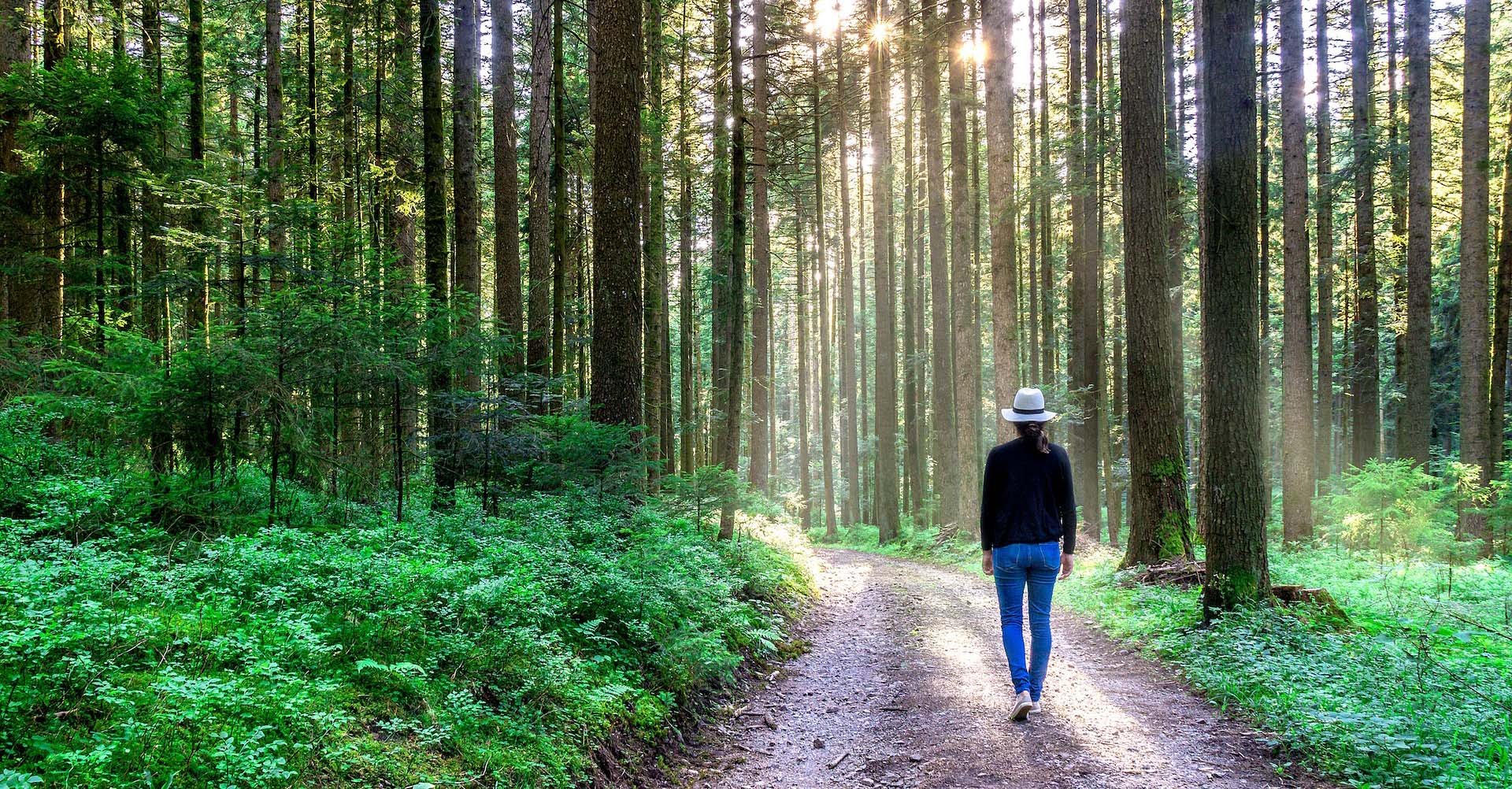 Kvinna promenerar ute i naturen.