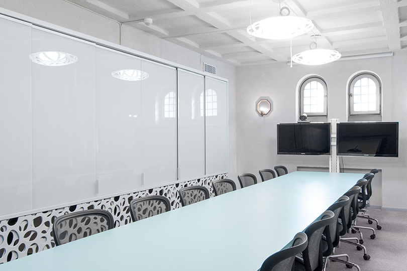 Modernt konferensrum i vitt med långt bord och gråa stolar. Certifiering GreenBuilding - så fungerar det.