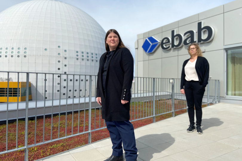 Två kvinnor på en balkong framför en Ebab-skylt med Globen i bakgrunden - Ebab presenterar hållbarhetsrapporten.