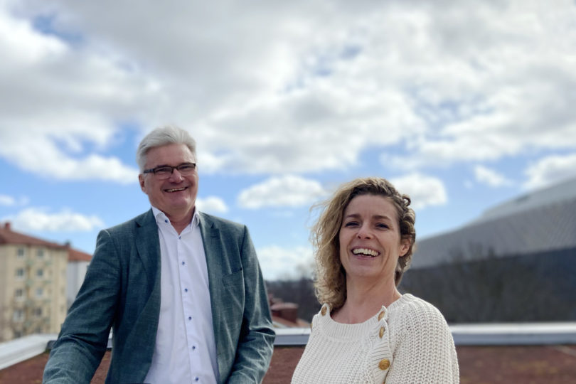 Halvkroppsporträtt med en man och en kvinna på en balkong med en molnig himmel i bakgrunden. Göran Westerberg och hållbarhetschef Ellinor OIsson.