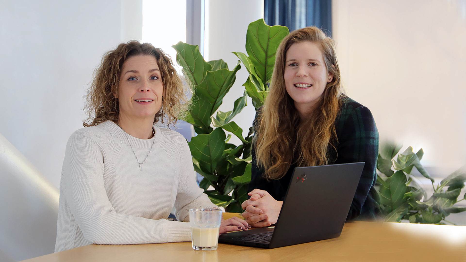 Halvbild på två kvinnor som står vid ett bord med en dator framför. Vår hållbarhetschef Ellinor Olsson och projektledare Anna-Maja Jöhnemark.