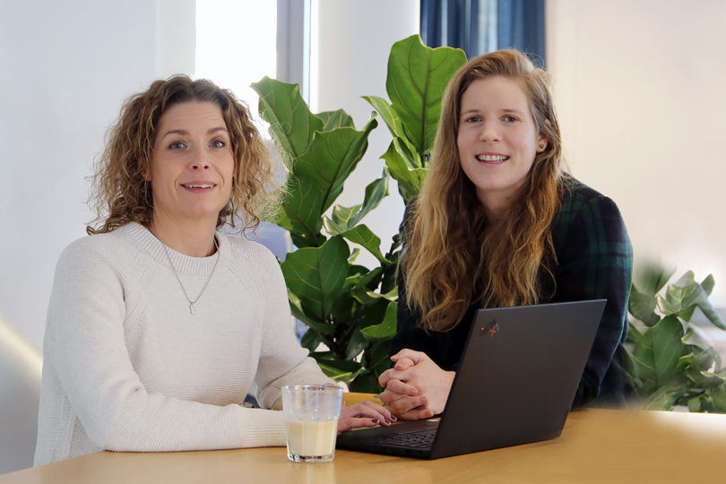 Halvbild på två kvinnor som står vid ett bord med en dator framför. Vår hållbarhetschef Ellinor Olsson och projektledare Anna-Maja Jöhnemark.