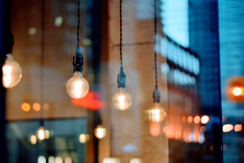 Nakna glödlampor hänger i svarta sladdar -energikonsultens 3 bästa tips för att spara energi.